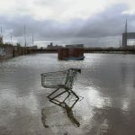 a shopping cart sitting in the middle of a flooded street